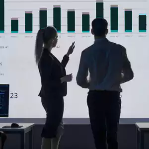 two business people’s hands next to a silver laptop